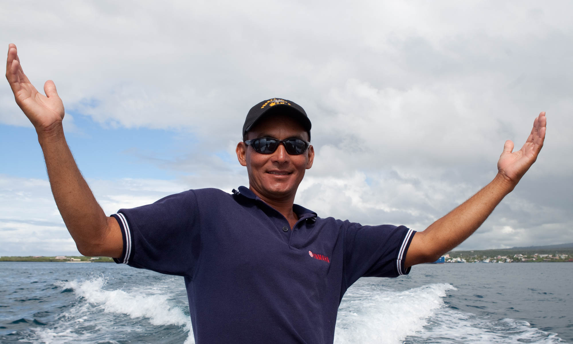 Man on boat with arms outstretched and smile on his face