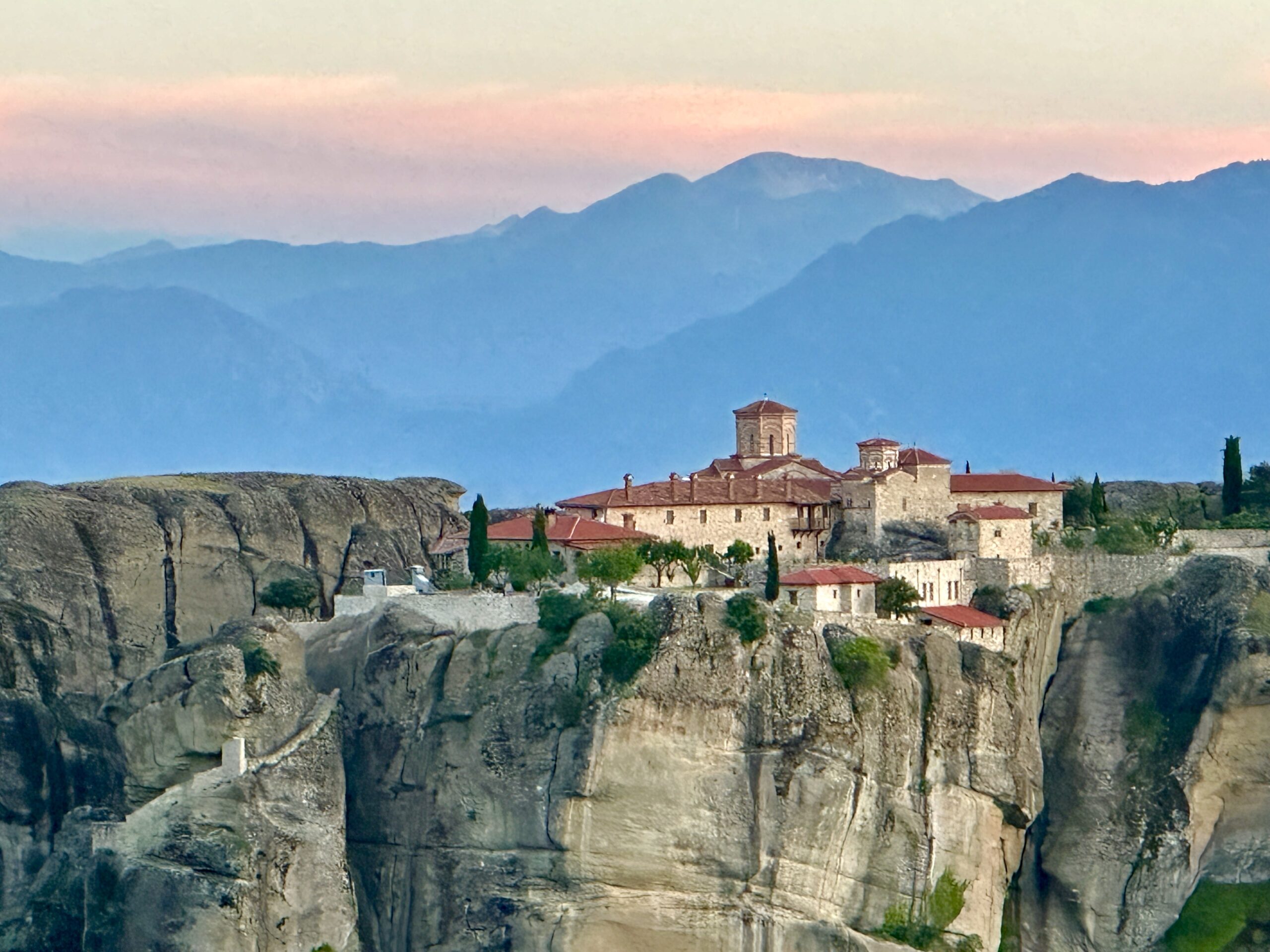 Sunset behind a monastery in the sky while visiting Meteora, Greece.